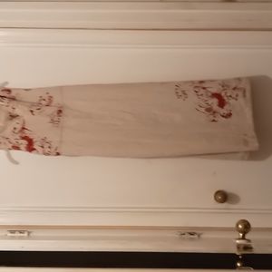 Women's short sleeved maxi cream dress with. Burgendy design around the collar